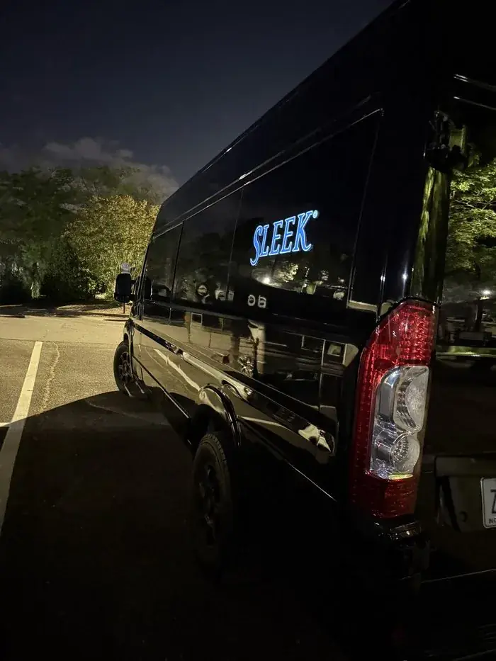 Illuminated Sleek Transportation logo on vehicle at night